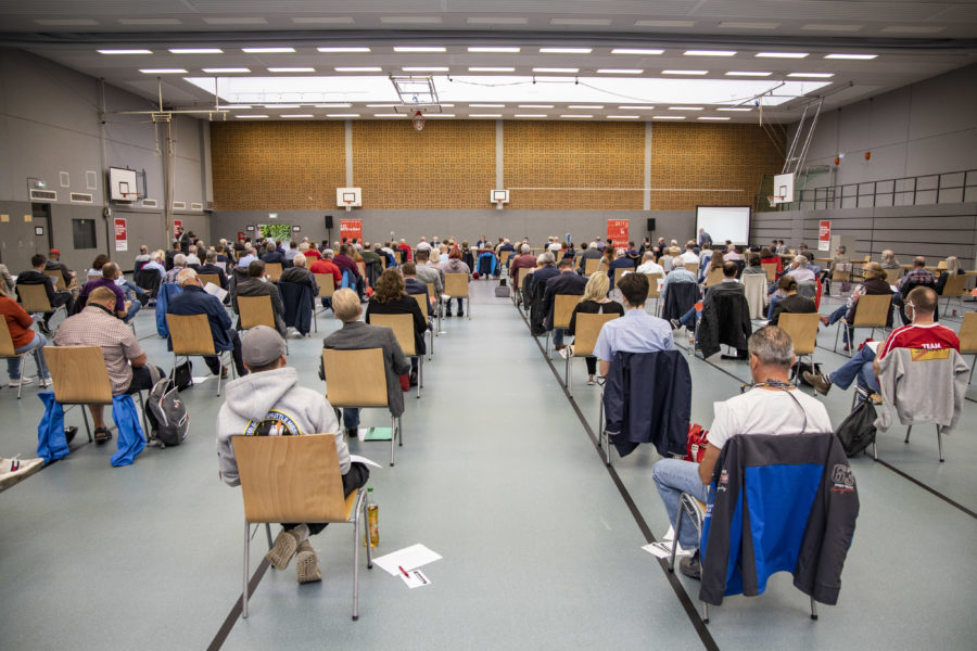 Ansicht der gefüllten Turnhalle in Richtung Sitzungsleitung, alle auf Abstand