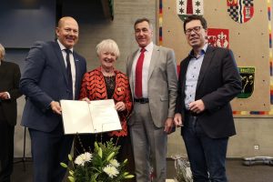 Landrat Frank Rock, Heidi Meyn, Bürgermeister Ralph Manzke, Dierk Timm präsentieren die Urkunde